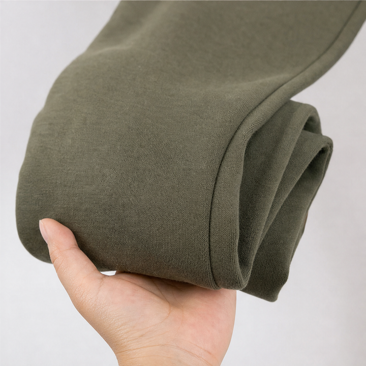 Hand holding the folded sleeve of an olive hooded coat