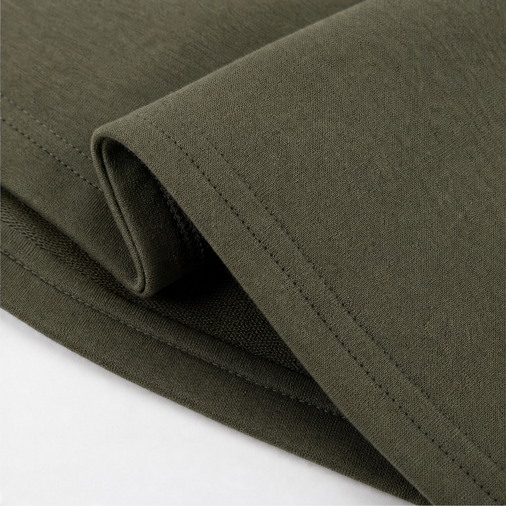 Stitched hem and side split on an olive hooded coat