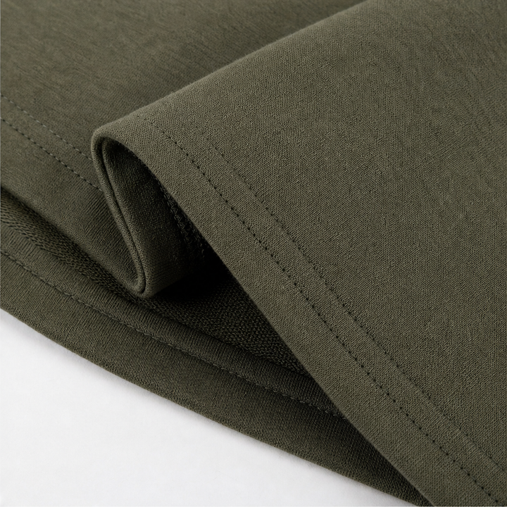 Stitched hem and side split on an olive hooded coat