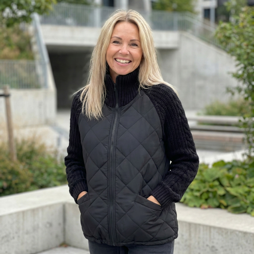 Black quilted puffer jacket with ribbed knit sleeves and a stand collar