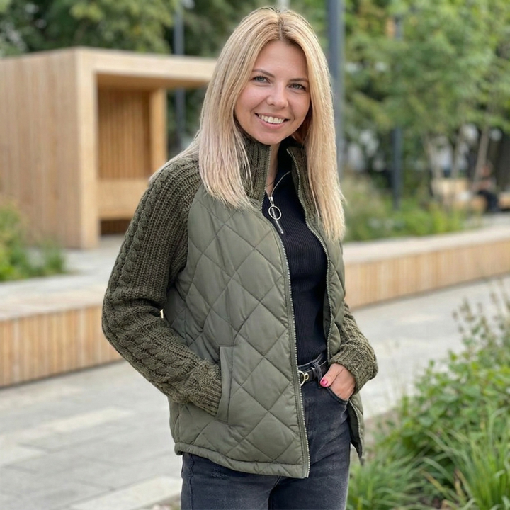Olive quilted puffer jacket with knitted sleeves worn with black jeans