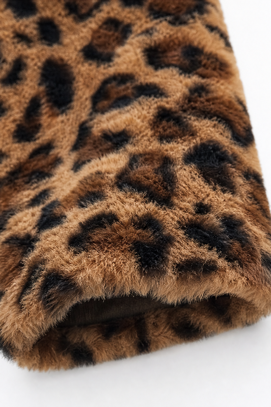 Folded sleeve detail of a leopard print faux fur coat