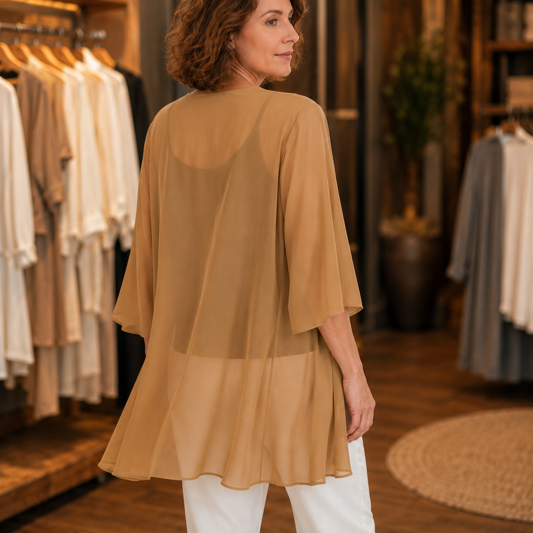 Back view of a camel chiffon open front cardigan in a shop