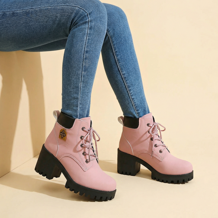 Pink lace-up platform ankle boots with black lug soles worn with jeans
