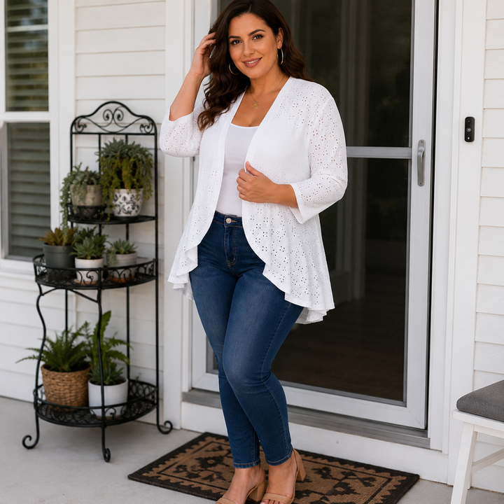 Woman by a front door in a white eyelet open front cardigan