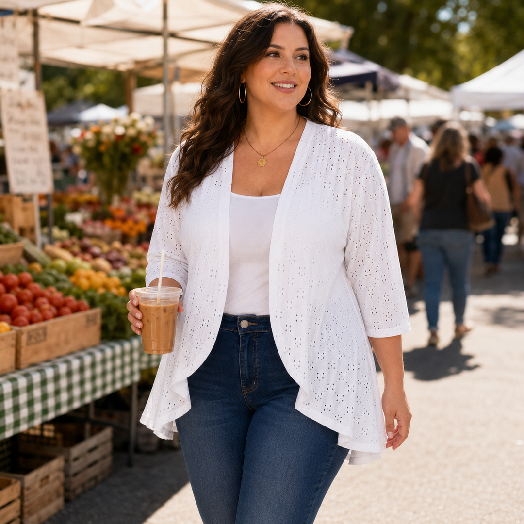 Woman at a farmers market in a white eyelet open front cardigan