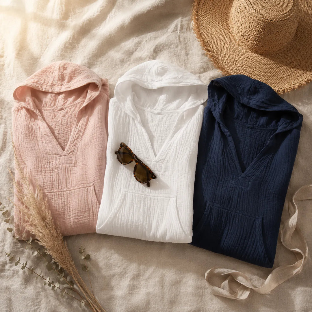 Three lightweight hooded tops folded in pink, cream and navy