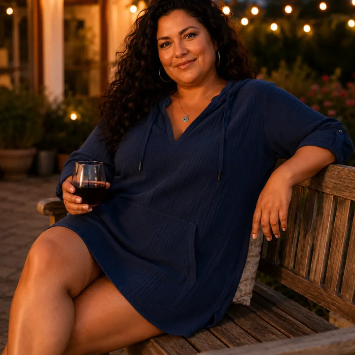 Woman with a wine glass in a navy lightweight V neck hooded top