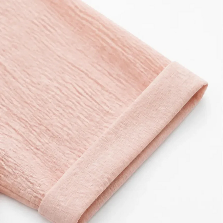 Folded sleeve and cuff detail on a blush pink hooded top