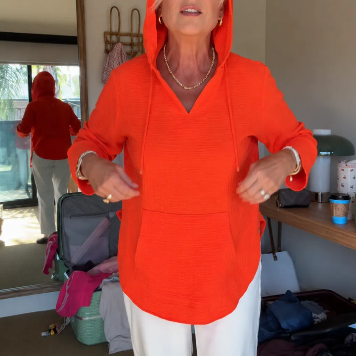 Orange red lightweight V neck hooded top with white trousers