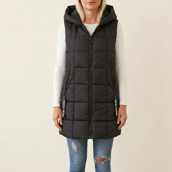 Black quilted hooded puffer vest over a white long sleeve top