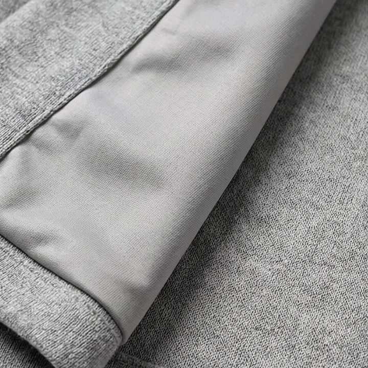 Close-up of a grey hooded cardigan jacket sleeve showing the smooth cuff panel and knit texture