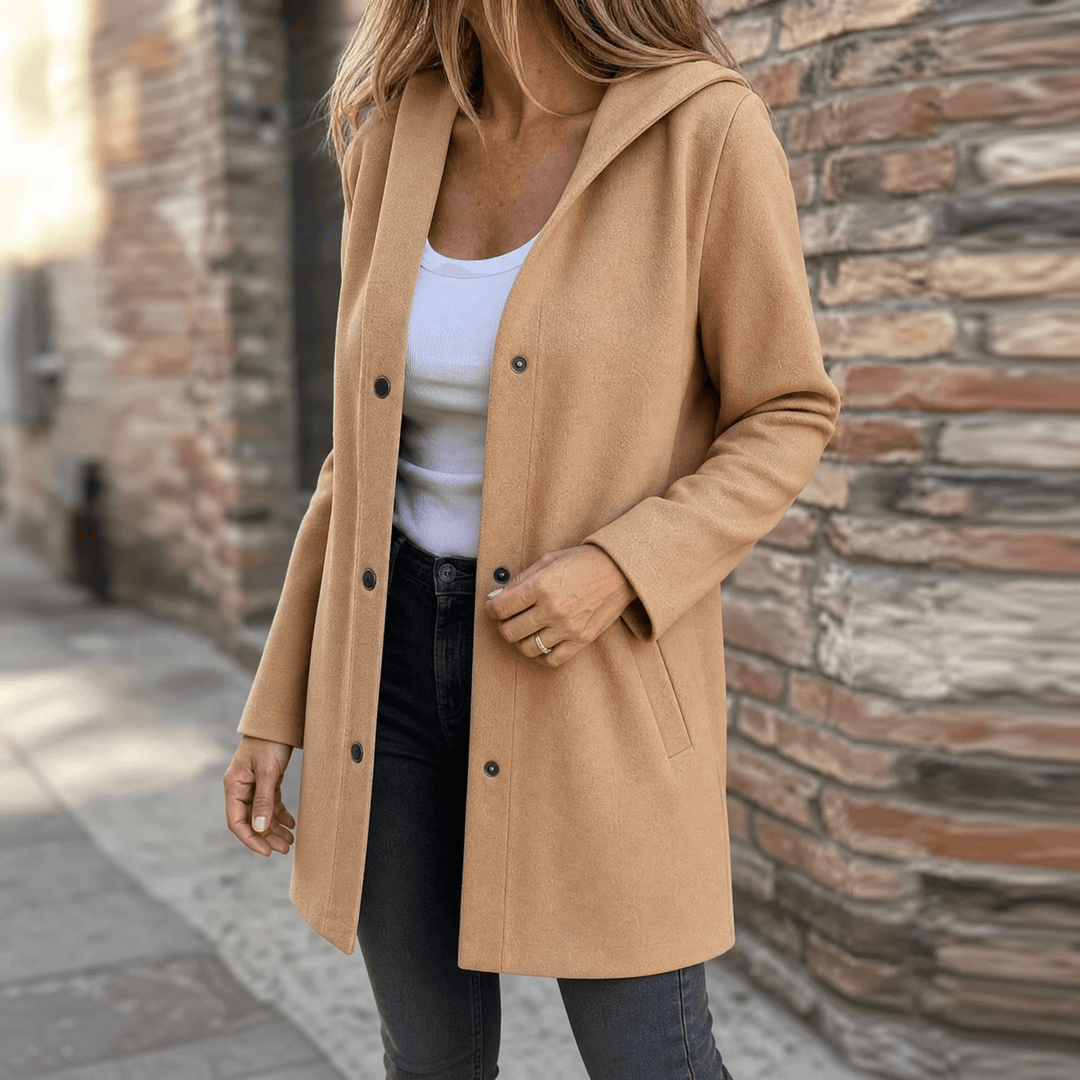 Woman wearing an open camel hooded cardigan jacket with black jeans on a city street