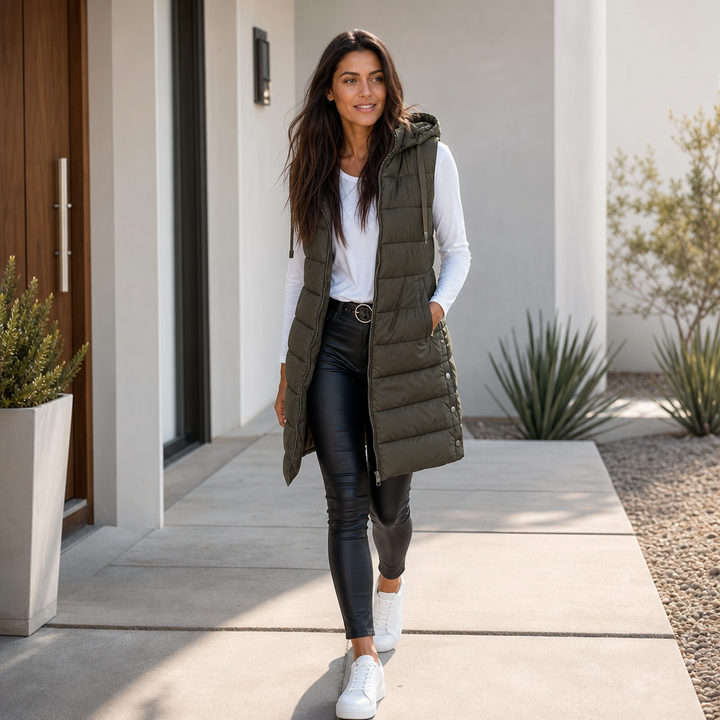 Olive longline quilted vest worn over a white top and black leggings