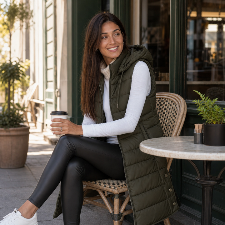 Woman with a coffee outside a cafe in an olive quilted vest