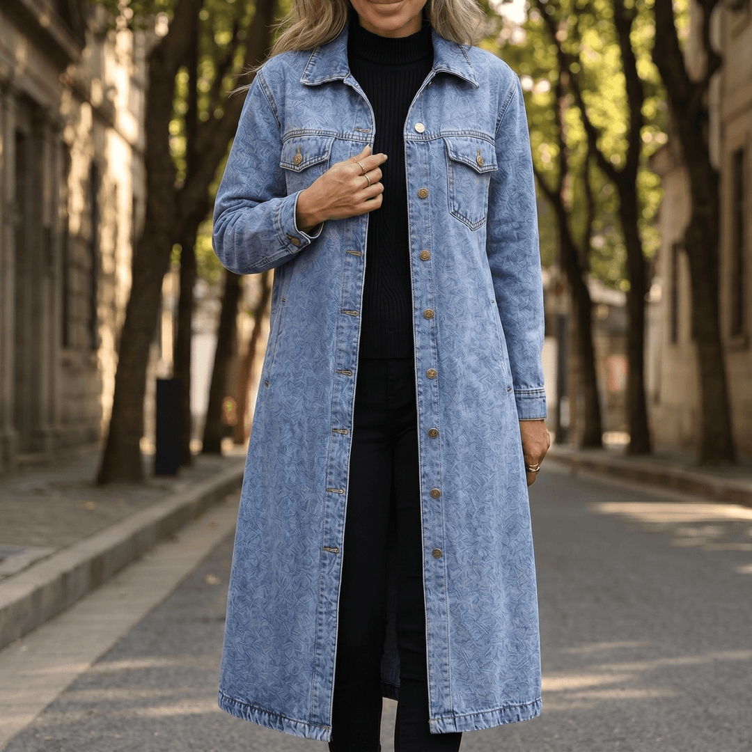 Mid blue longline denim coat worn open over a black outfit