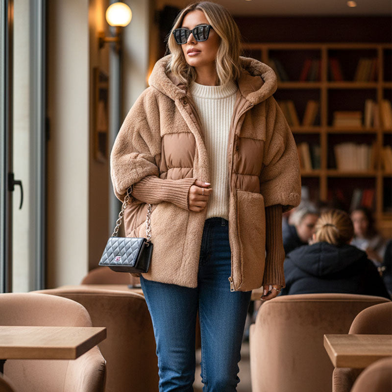 Camel quilted hooded jacket worn with jeans outside a cafe