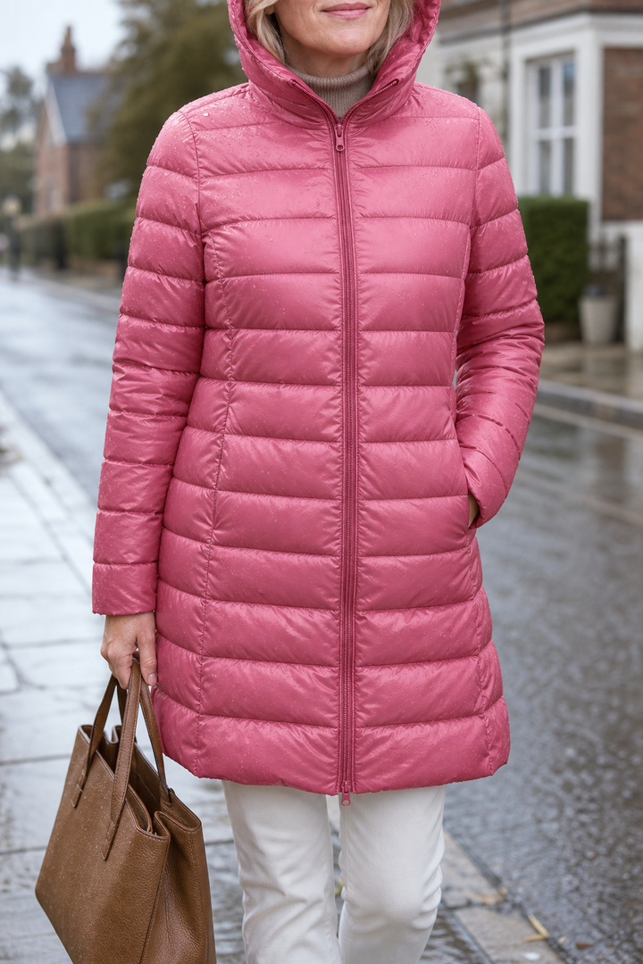 Pink ultralight puffer coat worn with white jeans on a street