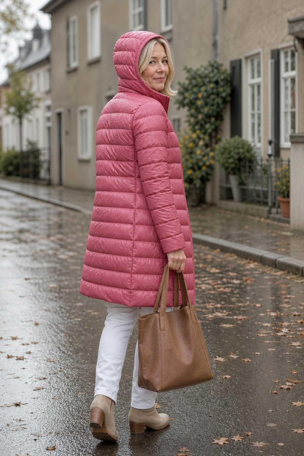 Pink hooded puffer coat with the hood up on a wet street