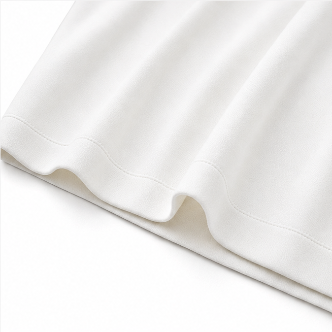 Close up of the stitched hem and soft drape of the ivory midi dress fabric