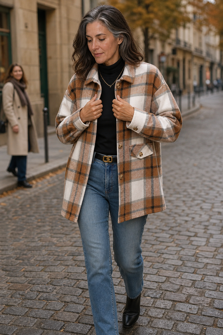 Woman walking a cobbled street in a camel plaid shirt jacket