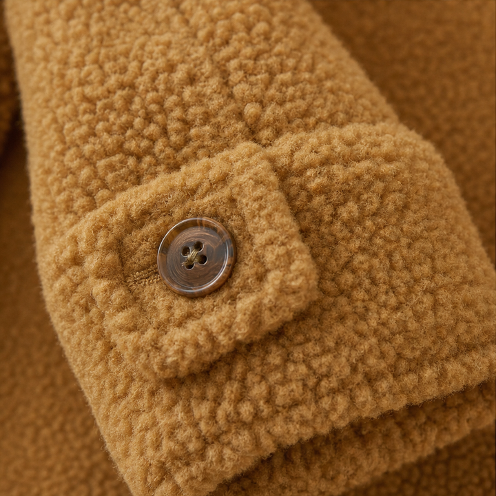 Buttoned tab on the collar of a caramel plush fleece jacket