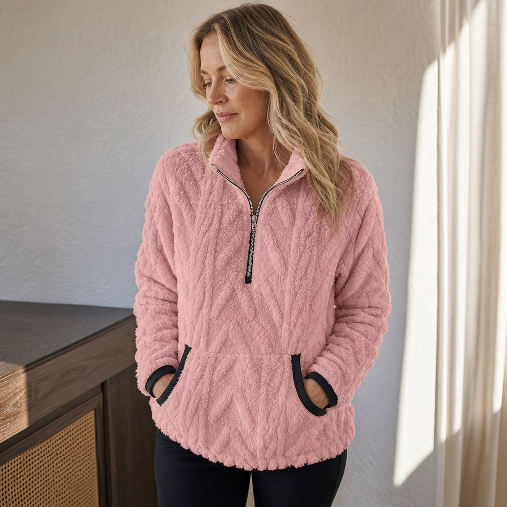 Woman by a window in a pink plush half zip fleece pullover