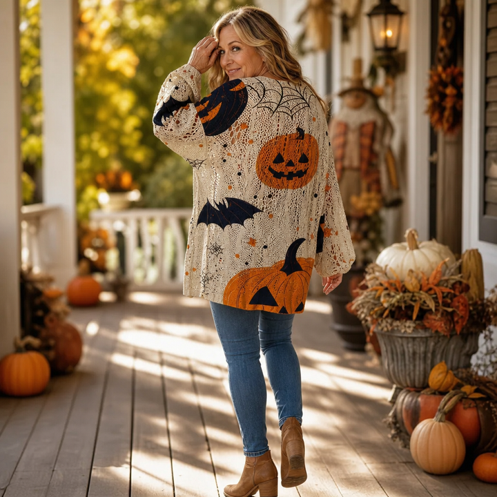Back view of a cream open-knit sweater with pumpkin, bat and spider web motifs