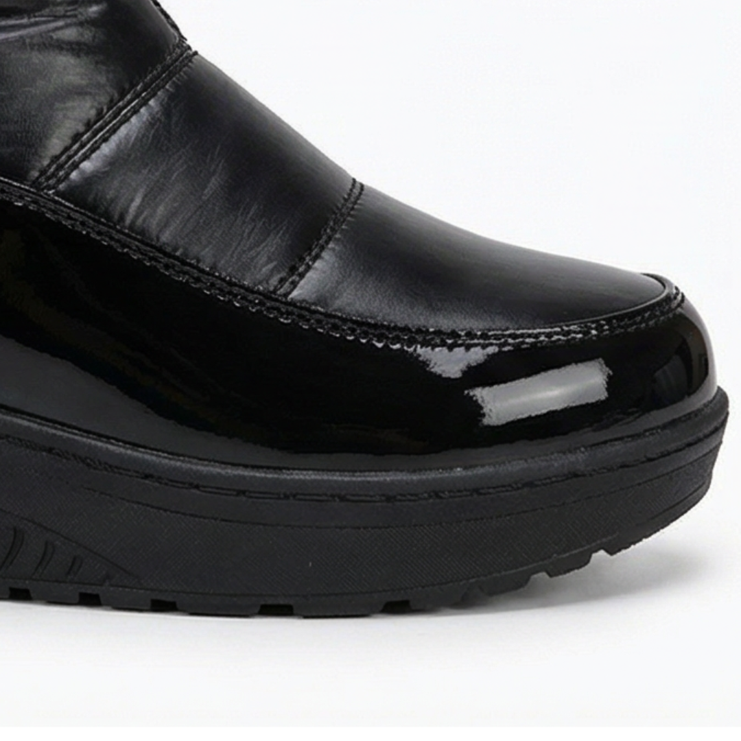 Wedge sole profile of a black quilted over the knee snow boot