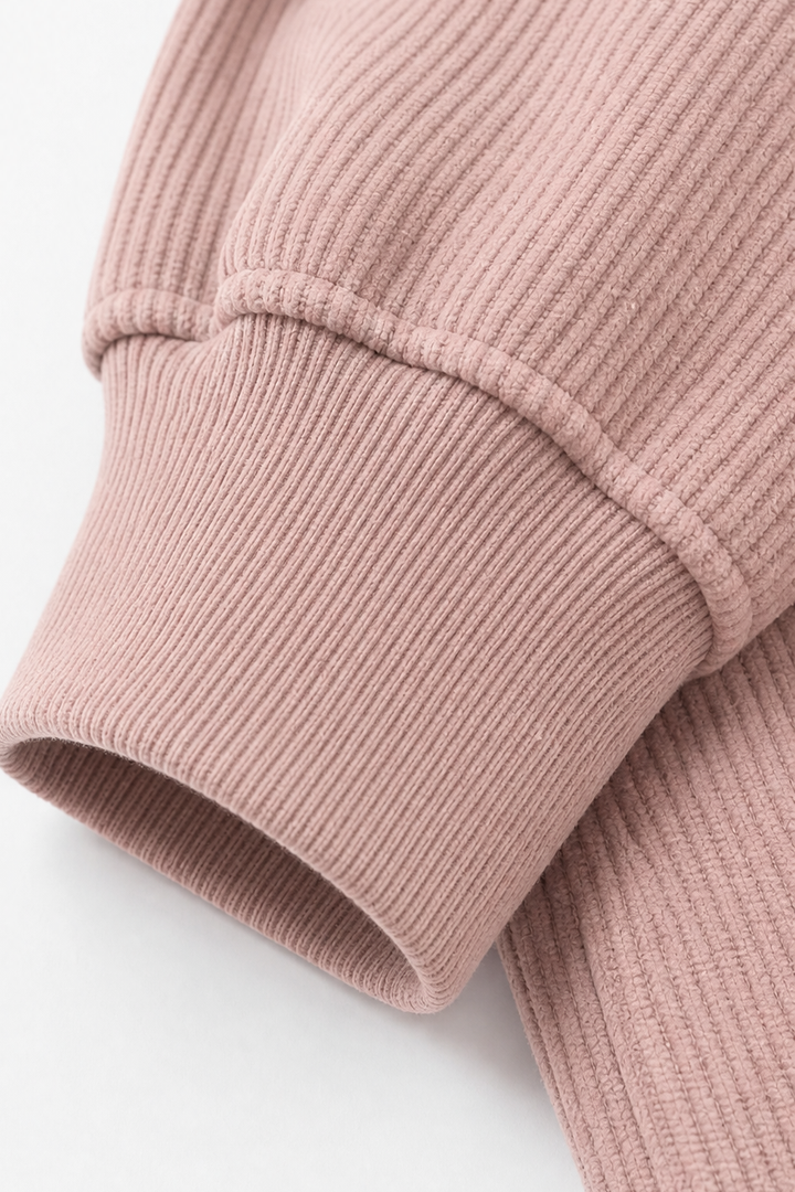 Folded ribbed cuff detail on a mauve hoodie sleeve