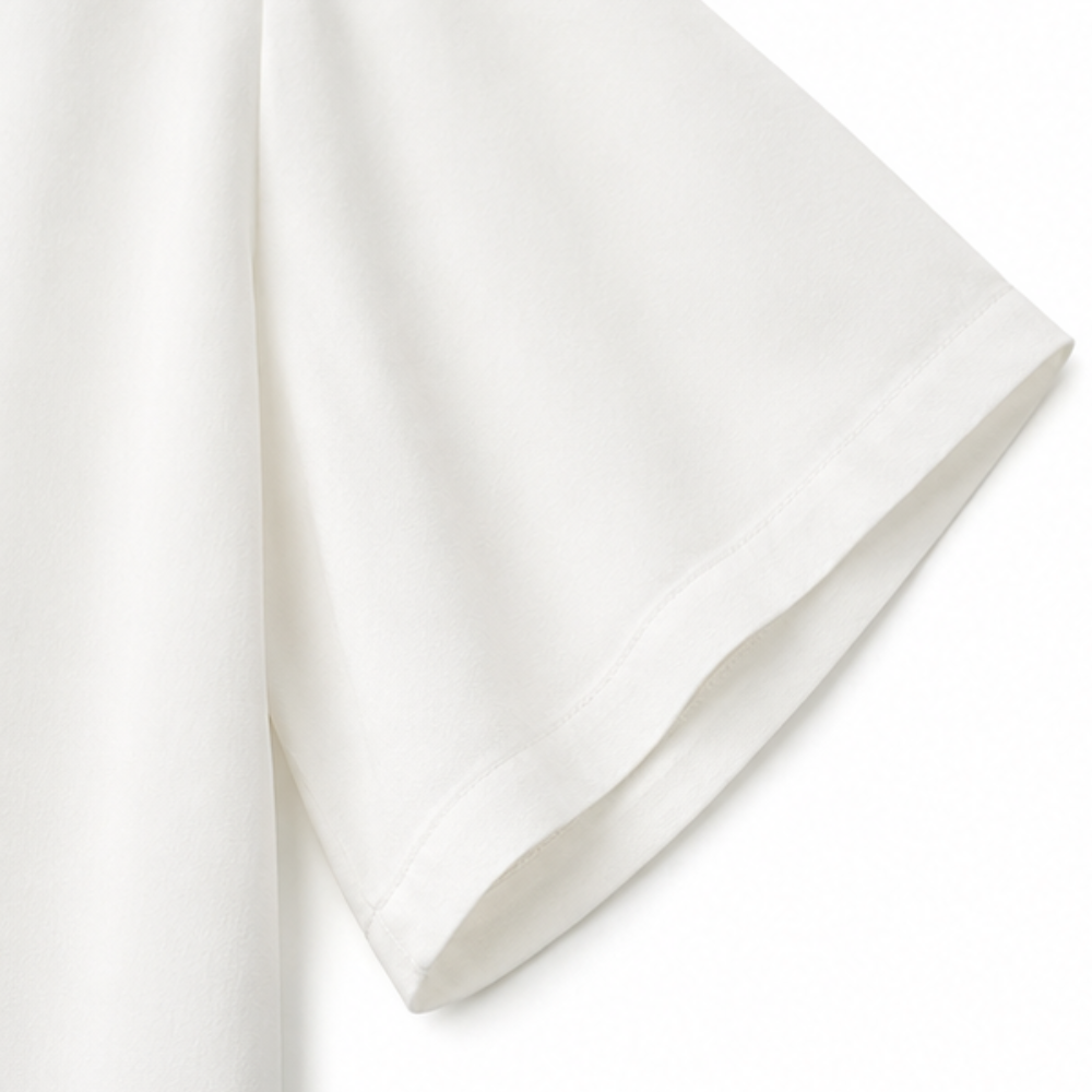 Close-up of the flared white sleeve and stitched hem of the blouse