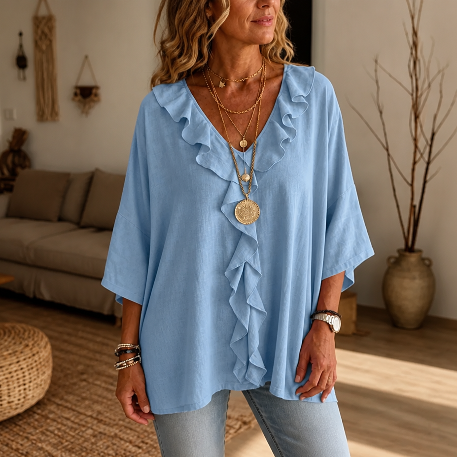 Light blue oversized blouse with ruffled V neck placket and wide sleeves, front view