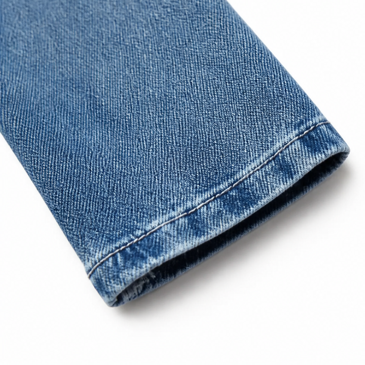 Stitched cuff detail on a blue denim jacket sleeve