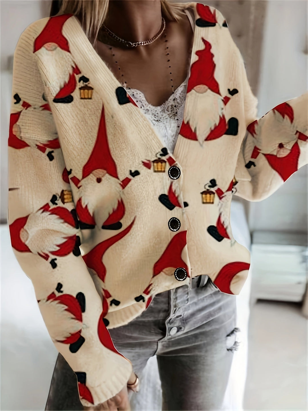 Cream knit cardigan with a red gnome print, buttoned front and long sleeves, worn with jeans