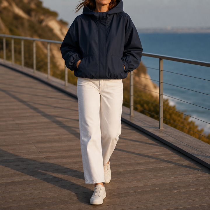 Woman on a coastal boardwalk in a navy balloon hem windbreaker