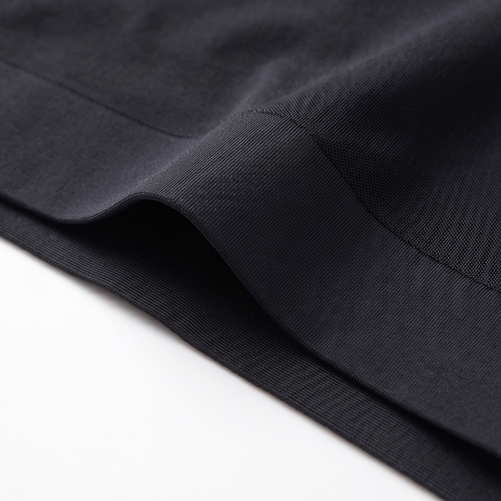 Folded black briefs showing the mesh panel seam