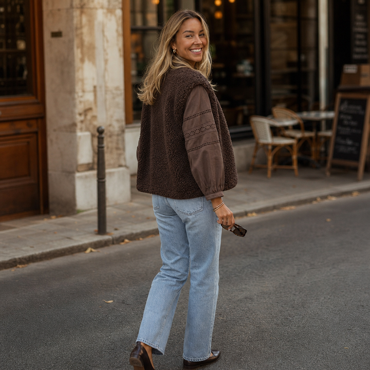 Back view of a brown teddy fleece vest on a cobbled street