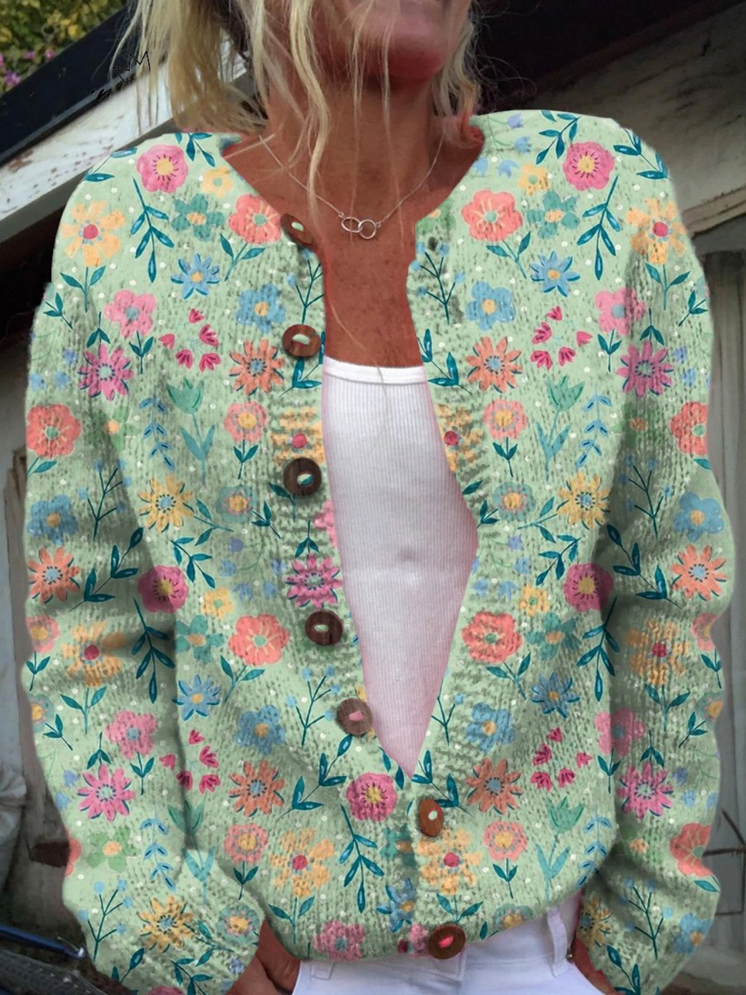 Light green knit cardigan with pink, blue and orange flower print and wooden buttons