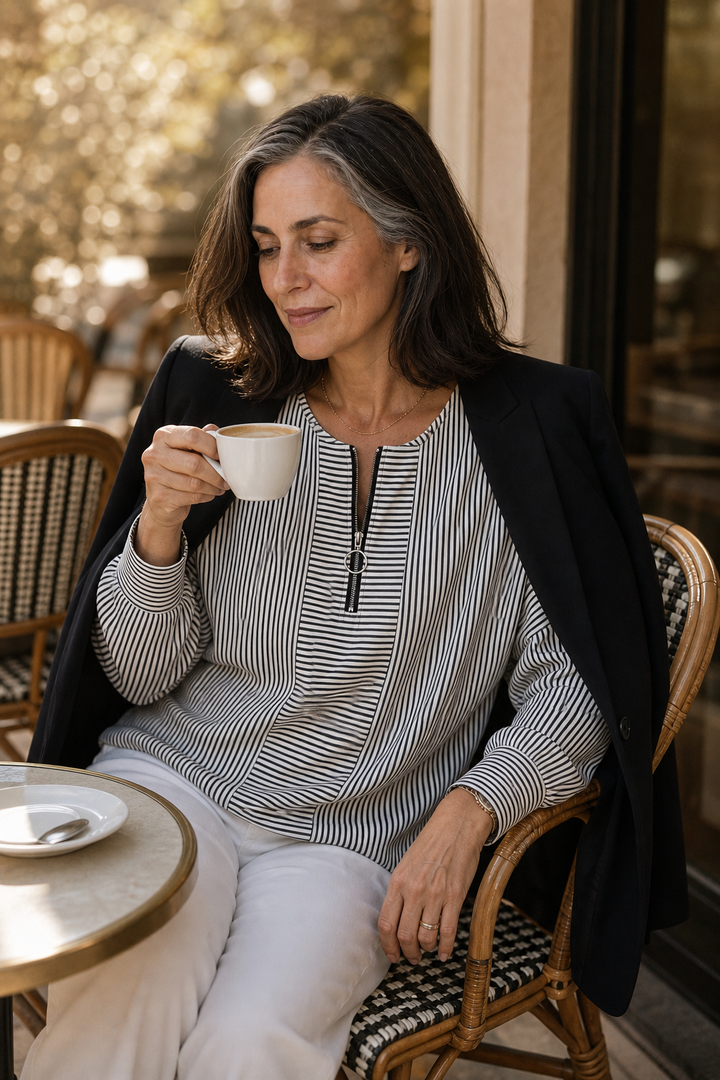 Woman with a coffee in a black striped quarter zip top