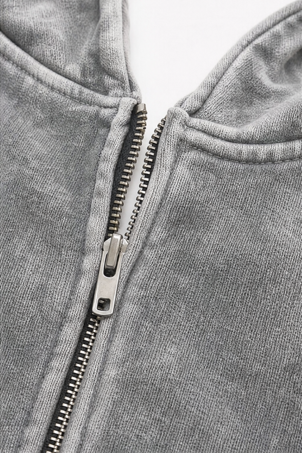 Metal zip and hood opening on a washed grey hoodie
