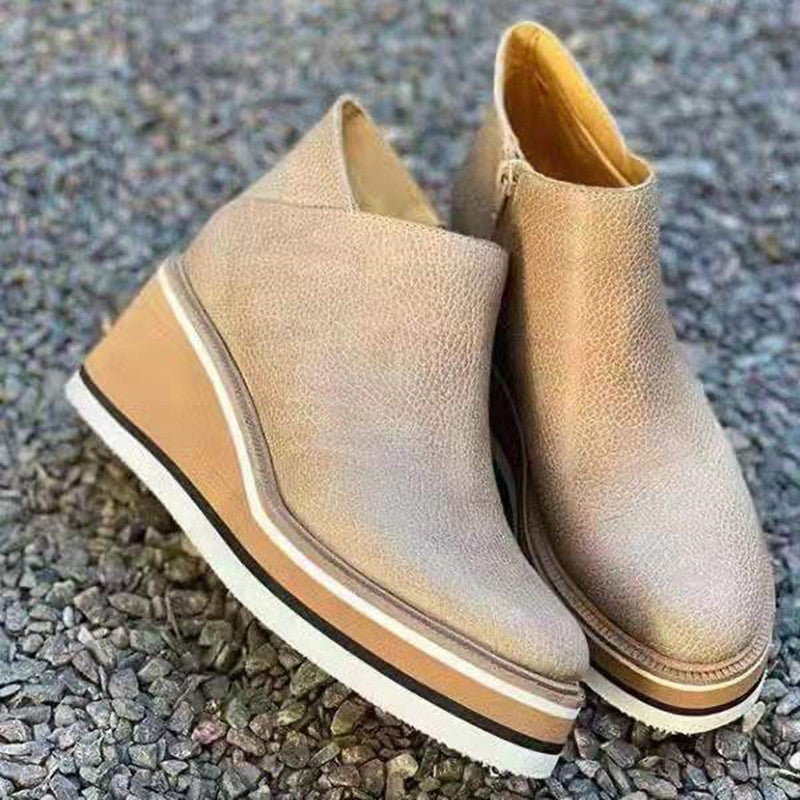 Pair of beige leather wedge ankle boots with a striped platform sole
