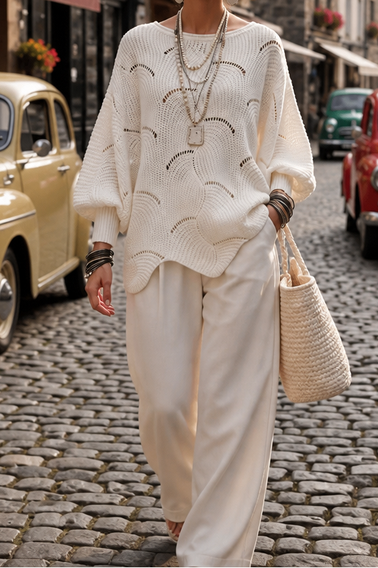Cream wave openwork batwing sweater worn with wide leg trousers