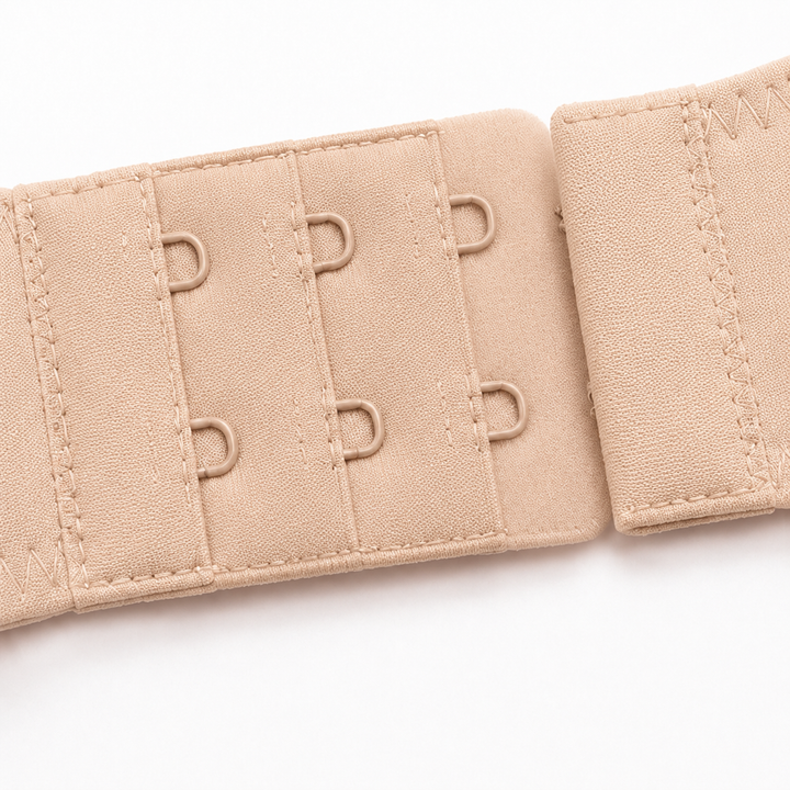 Close-up of the three-row hook-and-eye closure on a beige balconette bra
