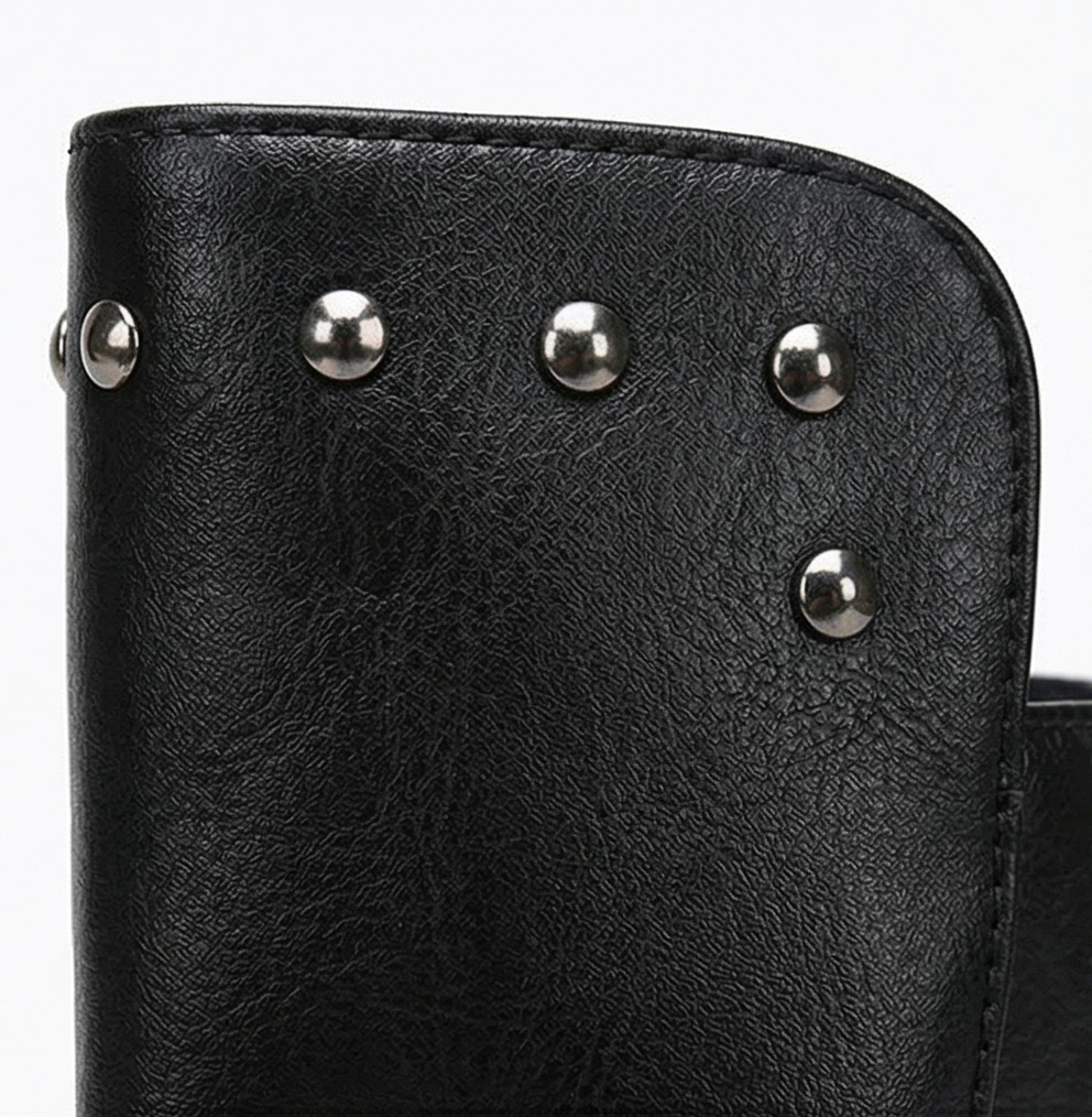 Close-up of the silver studs on the black leather shaft of a lace up boot